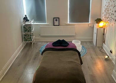 Tranquil massage room at Rooted Therapies by Vic in Whiston, England, GB, featuring a cozy bed and soft lighting.