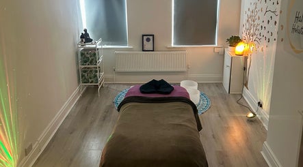 Tranquil massage room at Rooted Therapies by Vic in Whiston, England, GB, featuring a cozy bed and soft lighting.