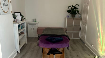 Relaxing spa room at Rooted Therapies by Vic in Whiston, England, GB, featuring a massage table and calming decor.
