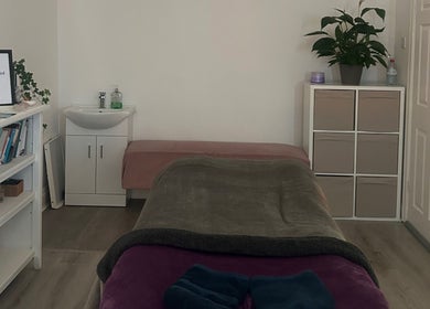 Tranquil therapy room at Rooted Therapies by Vic in Whiston, England, GB with cozy treatment bed and lush plants.