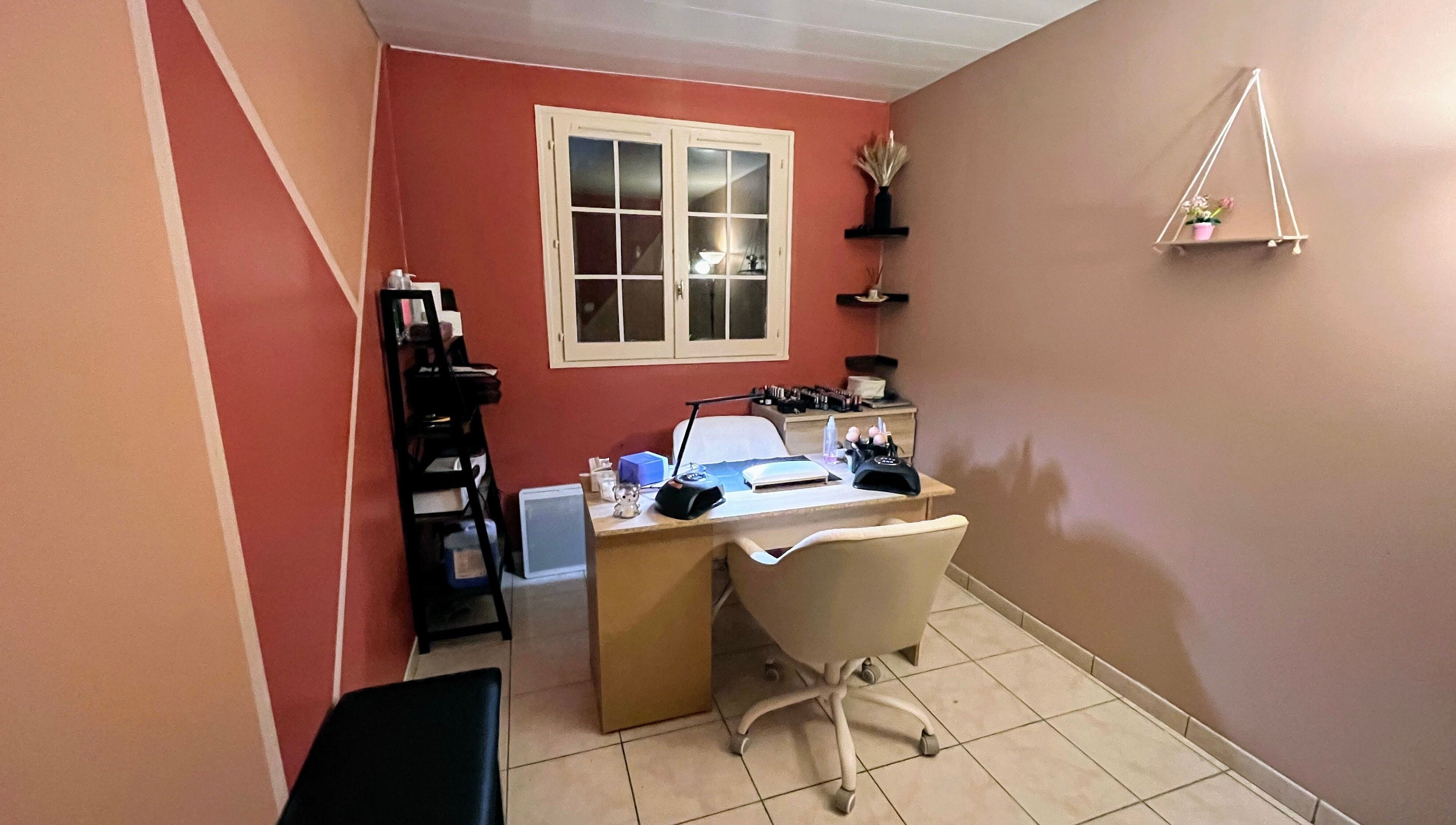 Salon de manucure élégant chez DivineNails à Chelles, Île-de-france, FR, avec mur corail et poste de travail.