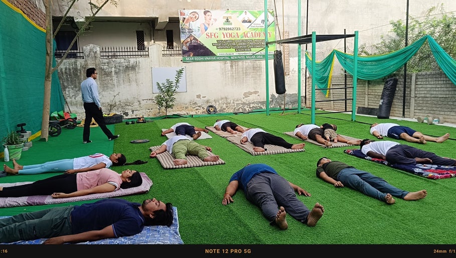 Yoga session at SFG Yoga Academy, Orai, Uttar Pradesh, IN, with participants practicing on mats outside.