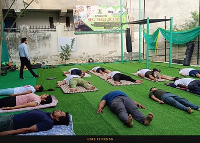 Yoga session at SFG Yoga Academy, Orai, Uttar Pradesh, IN, with participants practicing on mats outside.
