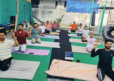 Group yoga session at SFG Yoga Academy, Orai, Uttar Pradesh, IN, with participants practicing outdoors.