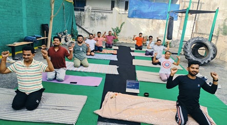 Group yoga session at SFG Yoga Academy, Orai, Uttar Pradesh, IN, with participants practicing outdoors.