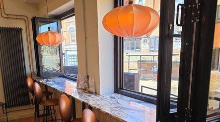 Chic seating in Remove Laser Clinic, Kimberley, England, GB with bright pendant lights and window views.