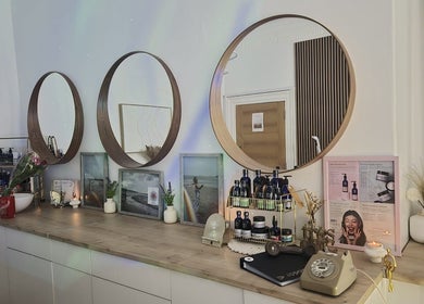 Elegant mirrors above a wooden counter at GC Therapies, Liverpool, England, GB, showcasing beauty products.