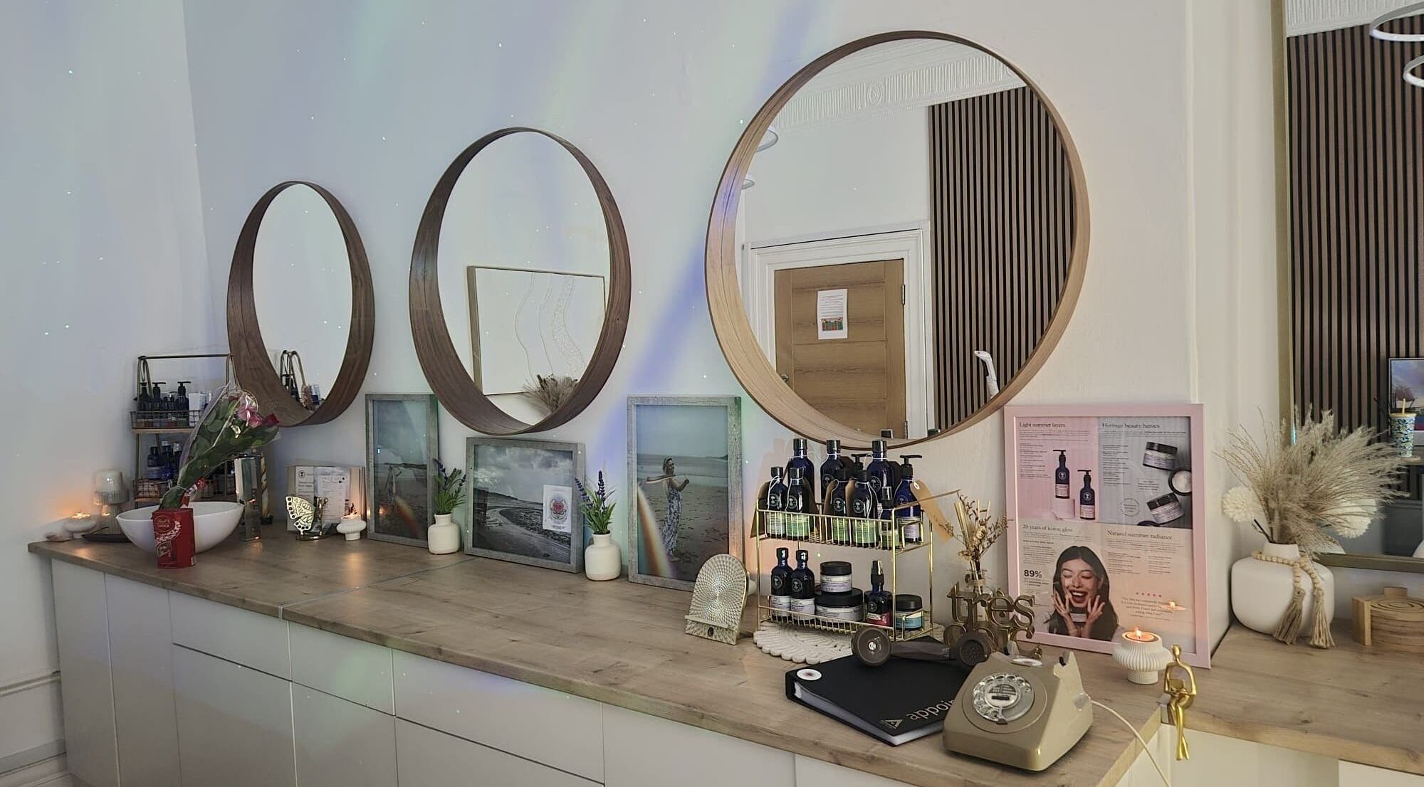 Elegant vanity at GC Therapies, Liverpool, England, GB featuring circular mirrors and wellness products.