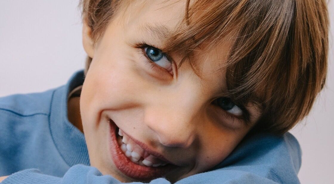 Kind met stralende glimlach bij JZ works, Zoetermeer, Zuid-Holland, NL, weerspiegelt vreugde.