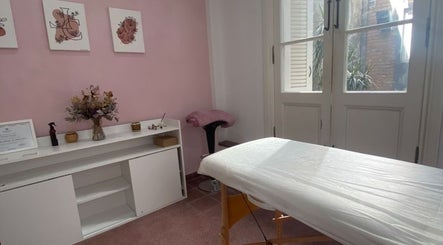 Sala de tratamiento relajante en Lashes Club, Concordia, Entre Ríos, AR, con paredes rosas y decoración elegante.