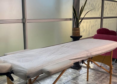 Sala de tratamiento en Lashes Club, Concordia, Entre Ríos, AR. Camilla cómoda junto a sofá y planta decorativa.