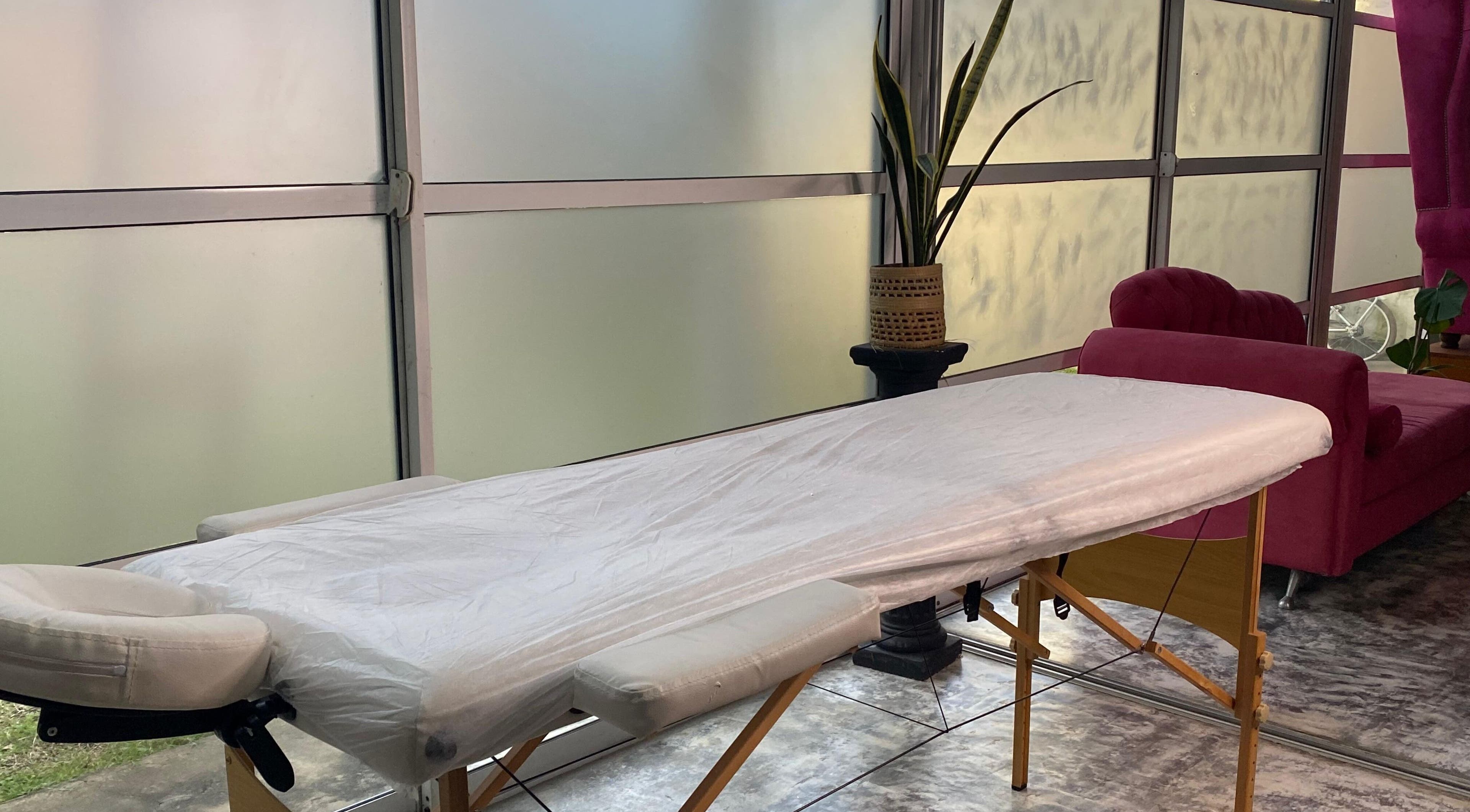 Sala de tratamiento en Lashes Club, Concordia, Entre Ríos, AR. Camilla cómoda junto a sofá y planta decorativa.