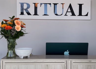 Reception desk at Eyecandy Aesthetics in Seneca, South Carolina, US with flowers and a laptop.
