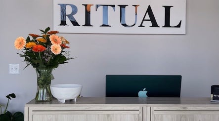 Reception desk at Eyecandy Aesthetics in Seneca, South Carolina, US with flowers and a laptop.