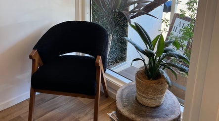 Inviting corner at SamBird Hair Artistry in East Toowoomba, Queensland, featuring a black chair and potted plant.