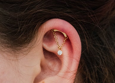 Elegant gold chain piercing at Colibri Tattoo and Piercing Ottawa, Ottawa, Ontario, CA.