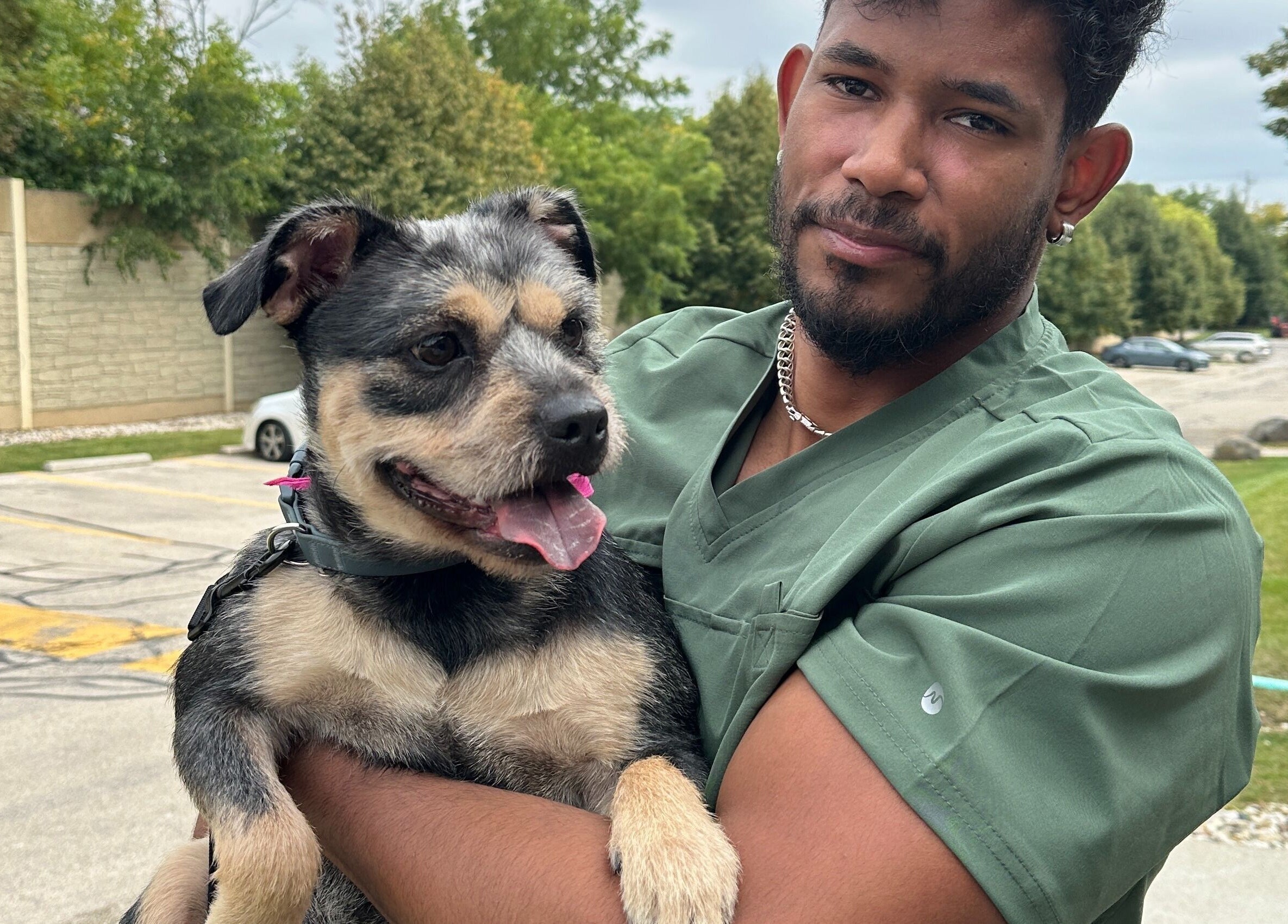 Groomer holding a happy dog at M&D Grooming, Greenfield, Wisconsin, US.