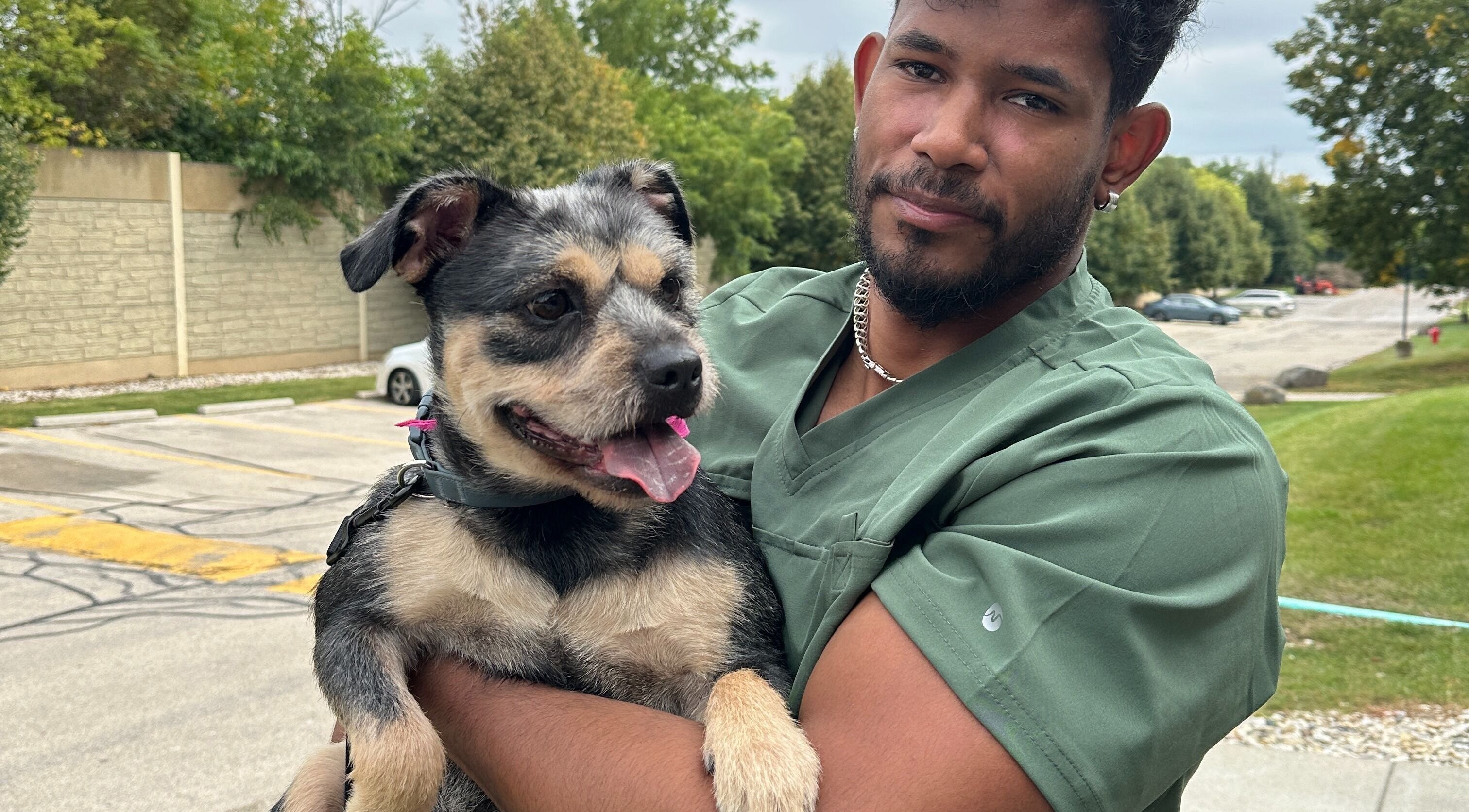 Groomer holding a happy dog at M&D Grooming, Greenfield, Wisconsin, US.