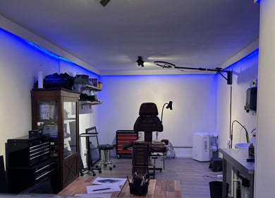 Interieur van Inko Tattoos studio, Zoetermeer, Zuid-holland, NL met moderne inrichting en verlichtingsaccenten.