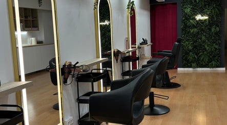 Interior moderno de PREMIUM SALÓN & SPA Pompeu Fabra, Mataró, Barcelona, ES con sillas de peluquería y espejo iluminado.