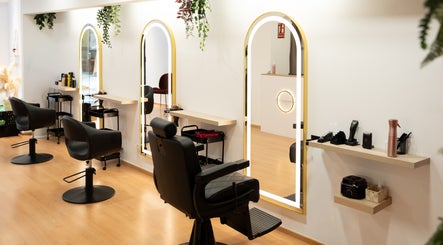 Interior moderno de Premium Salón & SPA Sant Benet en Mataró, Catalunya, ES con espejos y sillas elegantes.