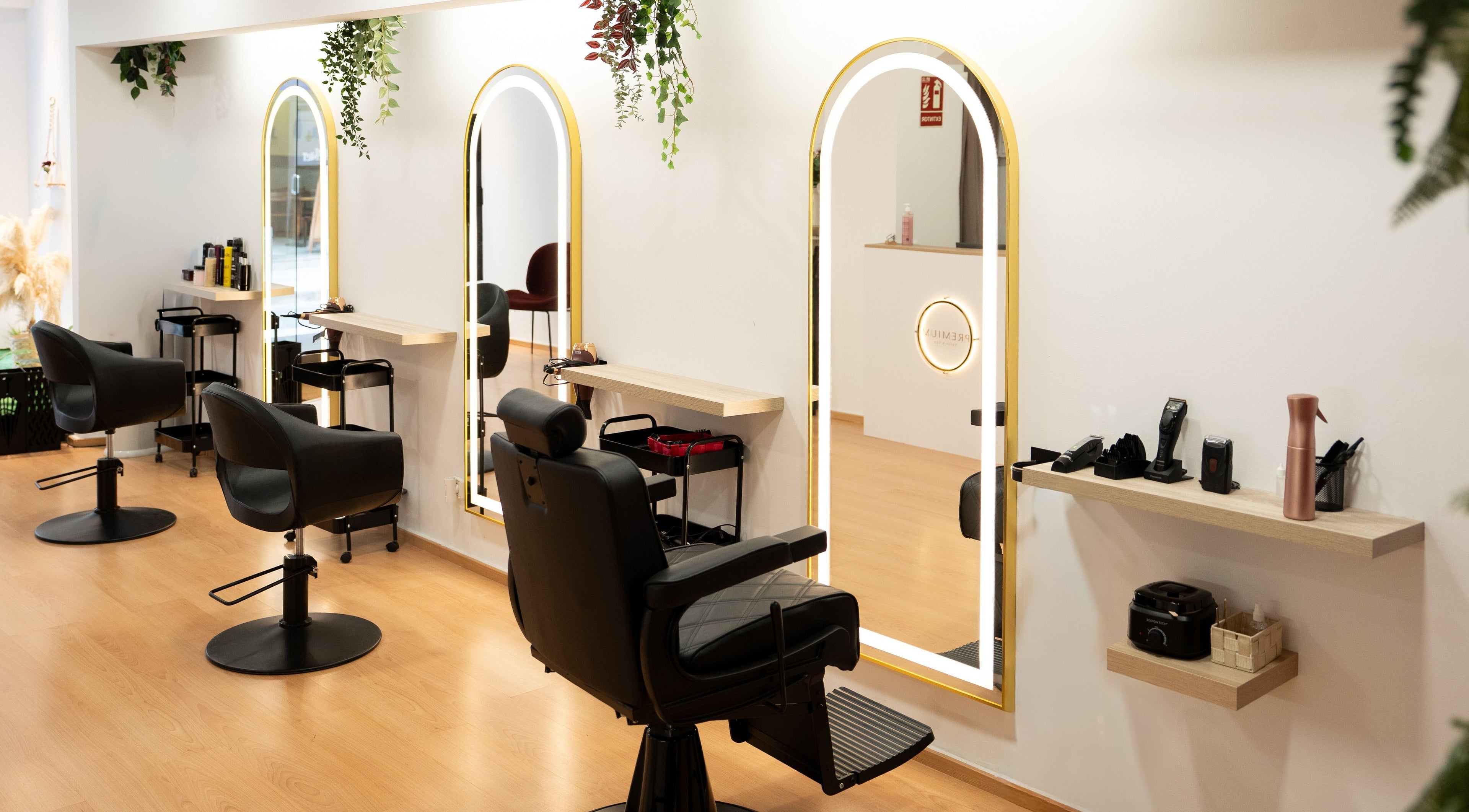 Interior moderno de Premium Salón & SPA Sant Benet en Mataró, Catalunya, ES con espejos y sillas elegantes.