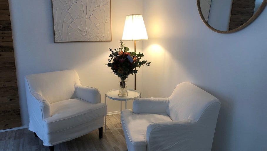 Inviting seating area at Beauty 2464, Yamba, New South Wales, AU, with white chairs and floral decor.