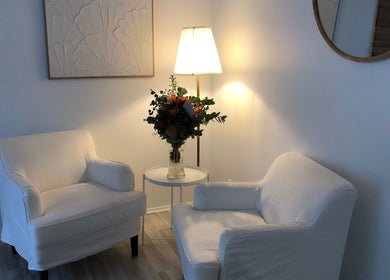 Inviting seating area at Beauty 2464, Yamba, New South Wales, AU, with white chairs and floral decor.