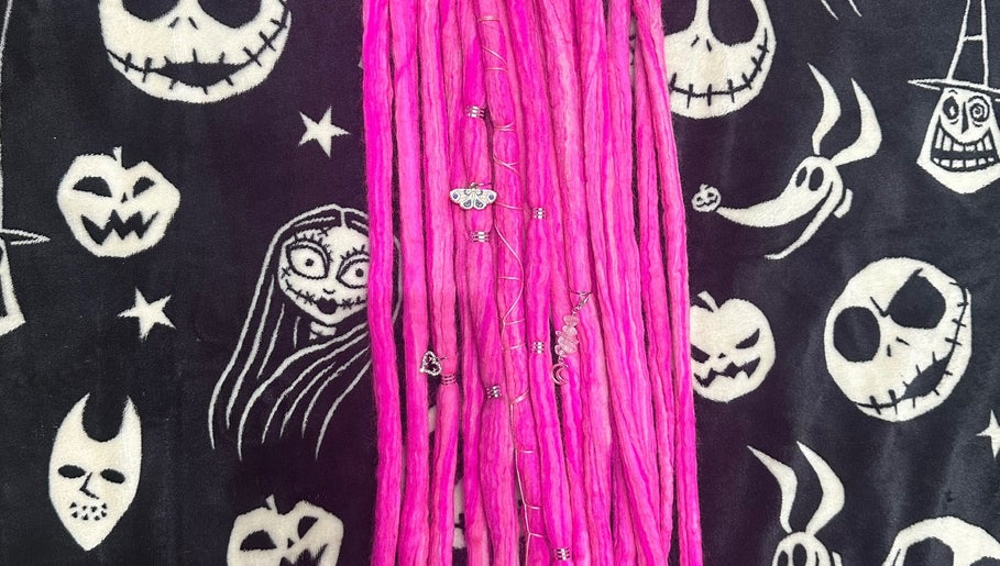 Vibrant pink locs from Whimsy Locs, Tuffley, England, GB, with Halloween-themed background.