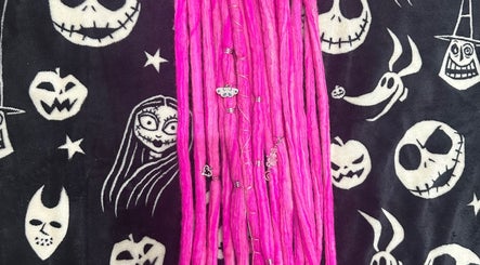 Vibrant pink locs from Whimsy Locs, Tuffley, England, GB, with Halloween-themed background.