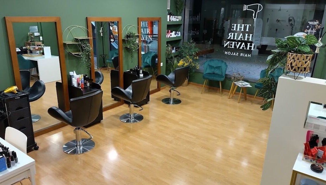 Το κομψό σαλόνι The Hair Haven στη Γλυφάδα, GR με καθίσματα και καθρέφτες.