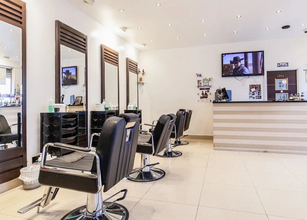 Modern salon interior at Ambiance Beauty, Hounslow, England, GB with stylish chairs and mirrors.