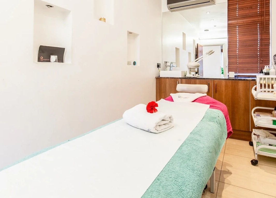 Serene massage room at Ambiance Beauty, Hounslow, England, GB. Features neatly folded towels and relaxing decor.
