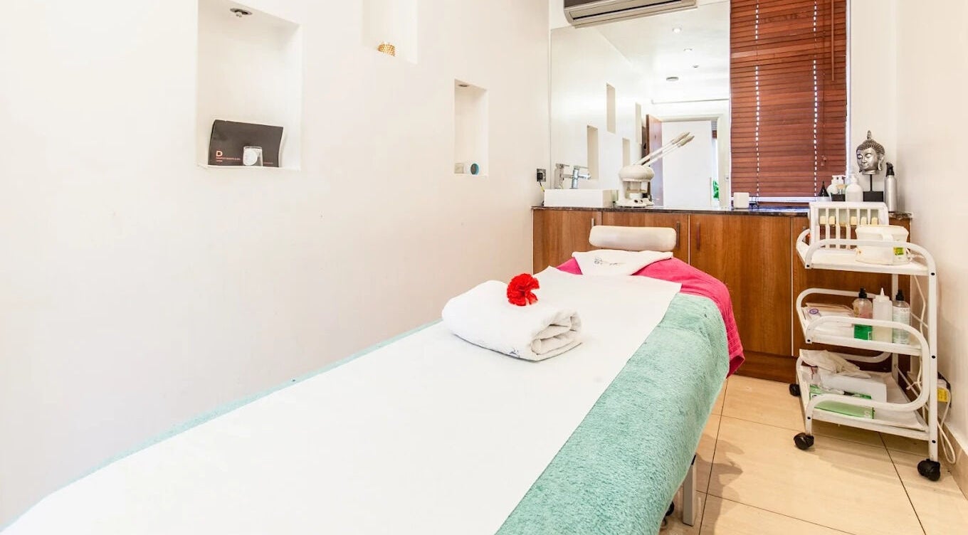 Serene massage room at Ambiance Beauty, Hounslow, England, GB. Features neatly folded towels and relaxing decor.