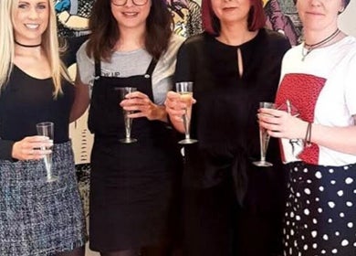 Team at SO Hair in Stafford, England, GB celebrates with drinks, smiling and enjoying their success.