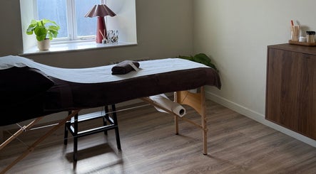 Tranquil massage room at Strp. in Edinburgh, Scotland, GB, featuring a cozy treatment table and plant decor.