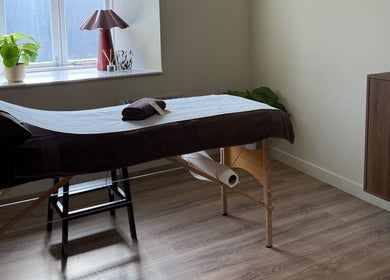 Serene massage room at strp. in Edinburgh, Scotland, GB with cozy table and calming decor.
