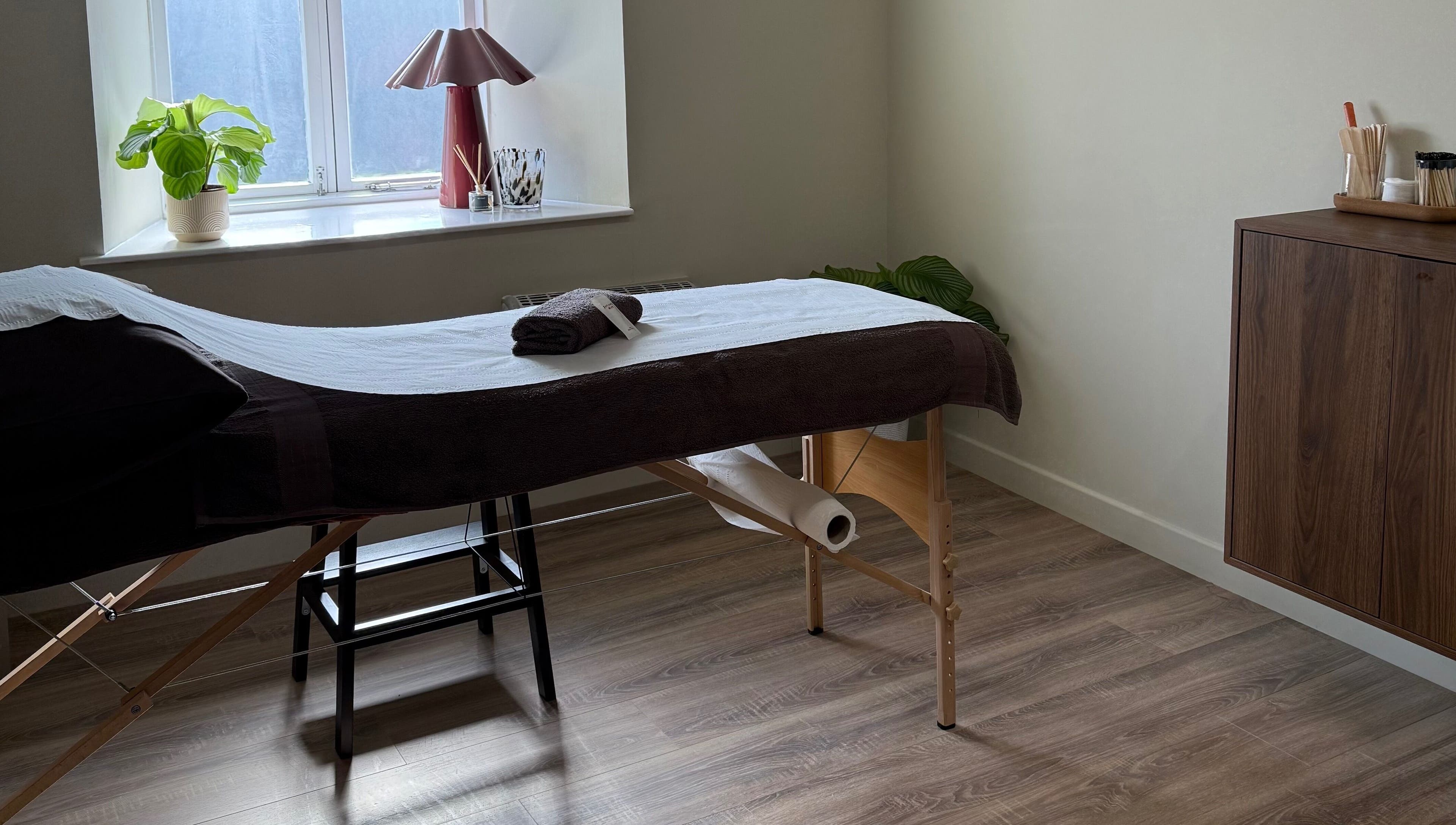 Relaxing therapy room at Strp. in Edinburgh, Scotland, GB, featuring a massage table by a sunlit window.