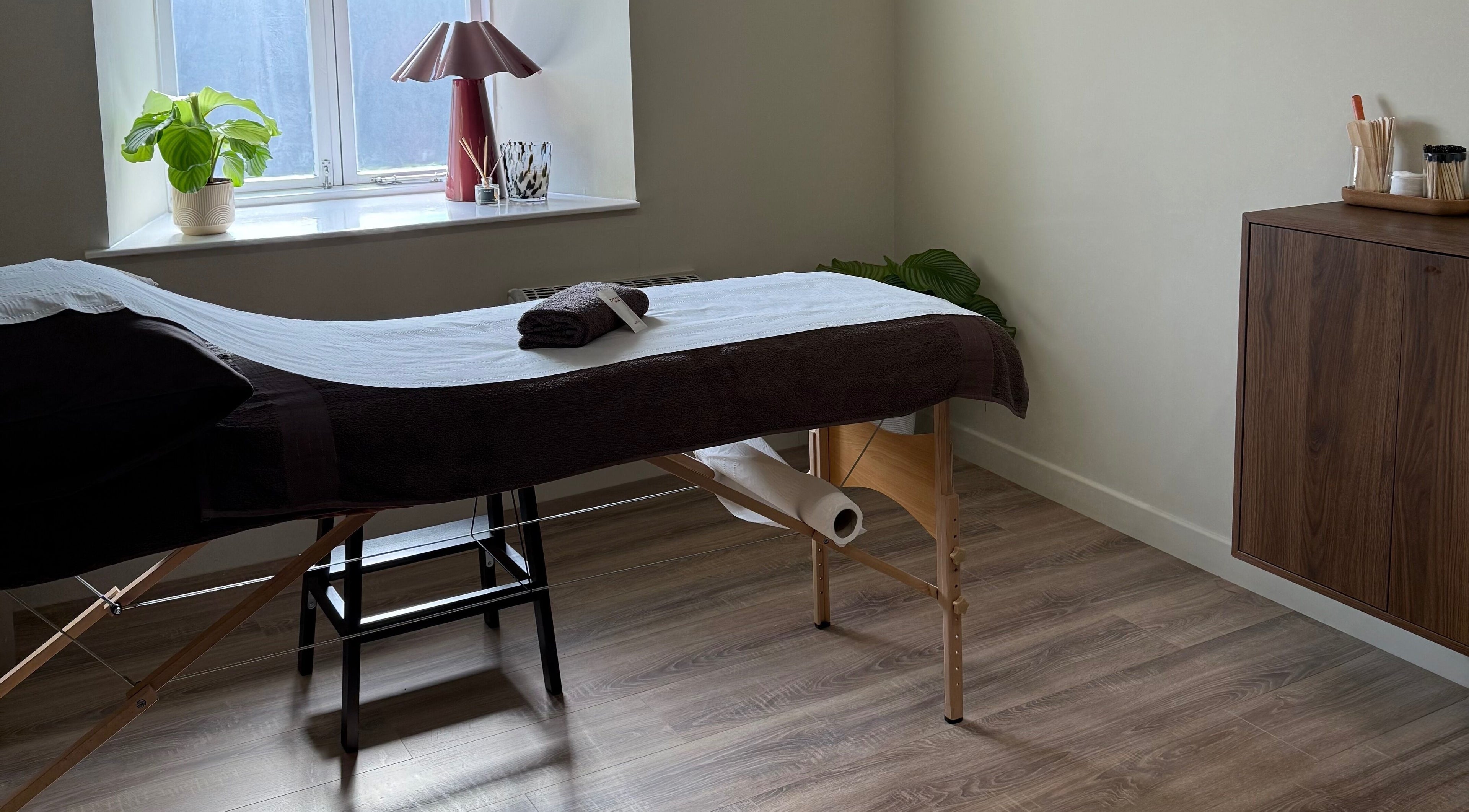 Relaxing therapy room at Strp. in Edinburgh, Scotland, GB, featuring a massage table by a sunlit window.