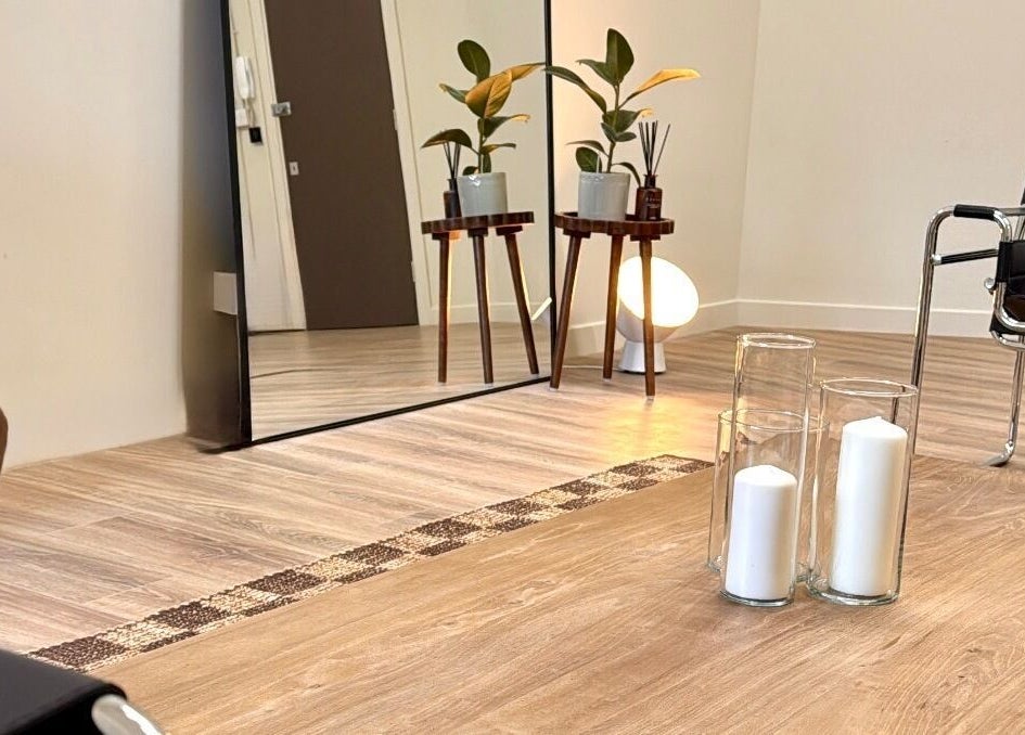 Stylish minimalist lounge in Strp. venue, Edinburgh, Scotland, GB. Features wood flooring, plants, and candles.