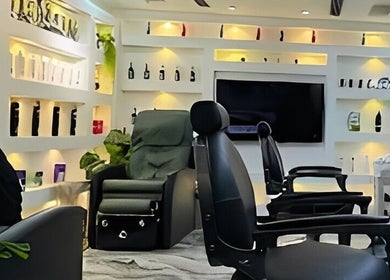 Elegant interior of 700 Gents Salon - Voco, Dubai, Dubai, AE showcasing modern barber chairs and illuminated shelves.