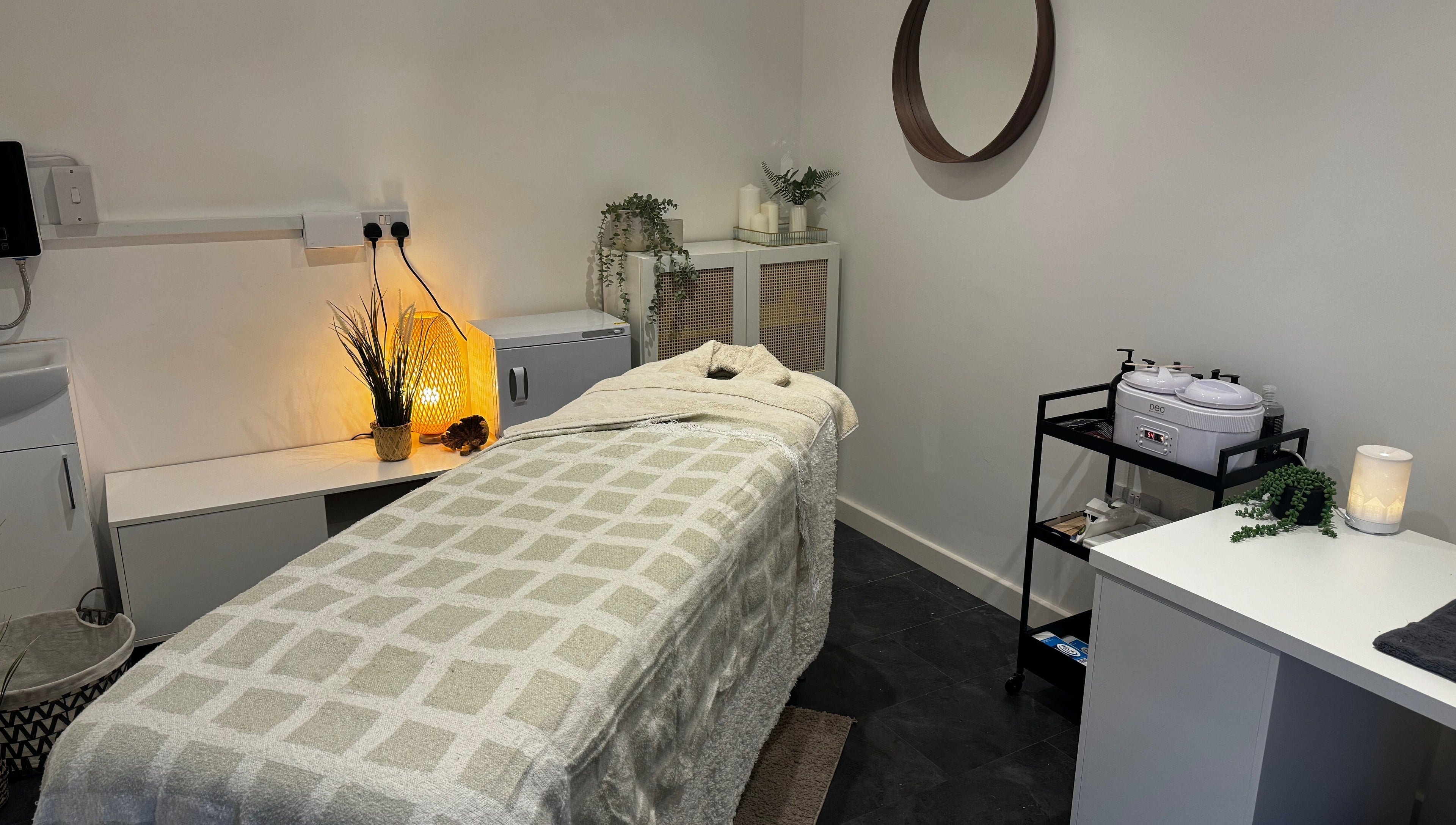 Cozy treatment room at Beauty By Mols, Somerton, England, GB, featuring a softly lit massage bed.