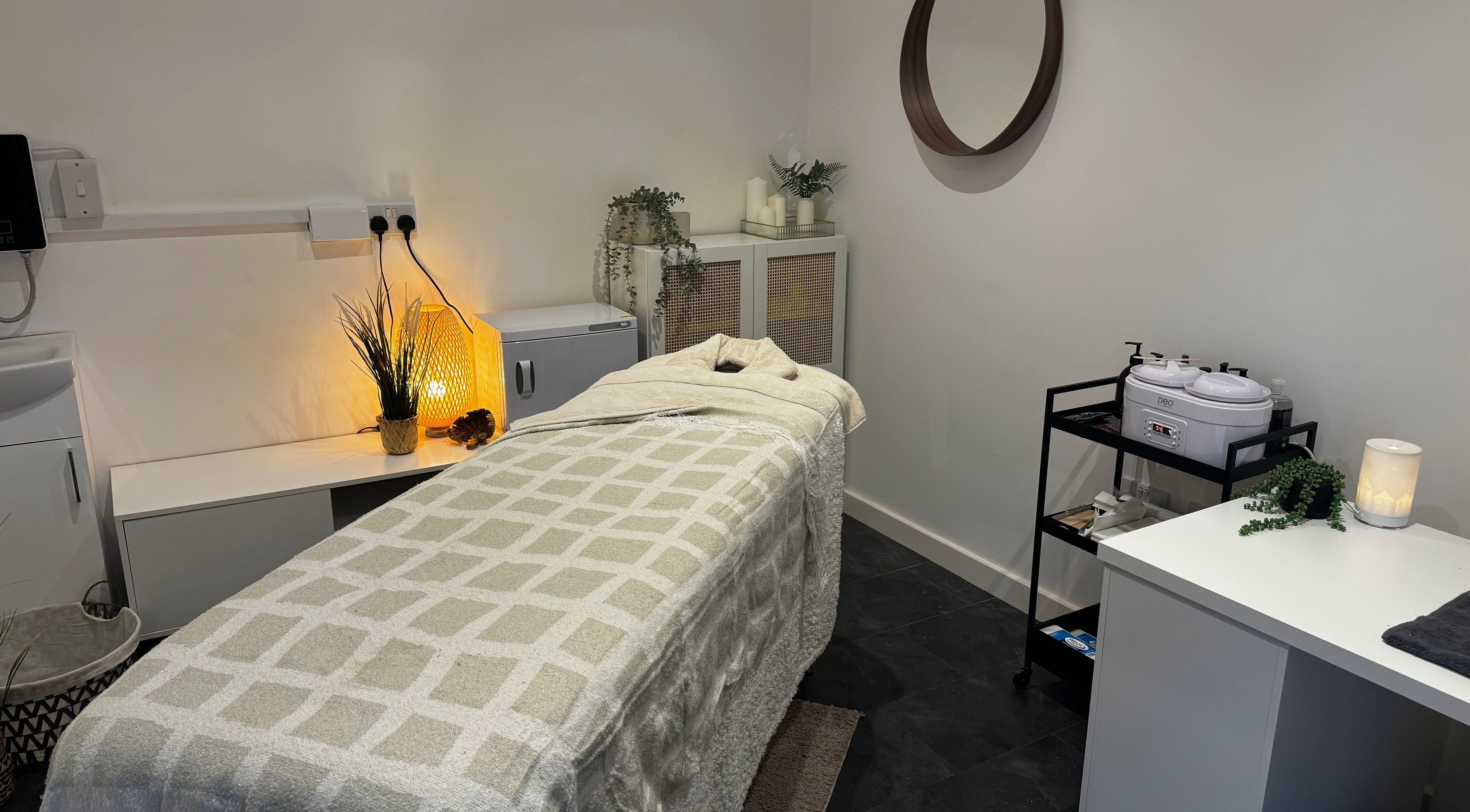 Cozy treatment room at Beauty By Mols, Somerton, England, GB, featuring a softly lit massage bed.