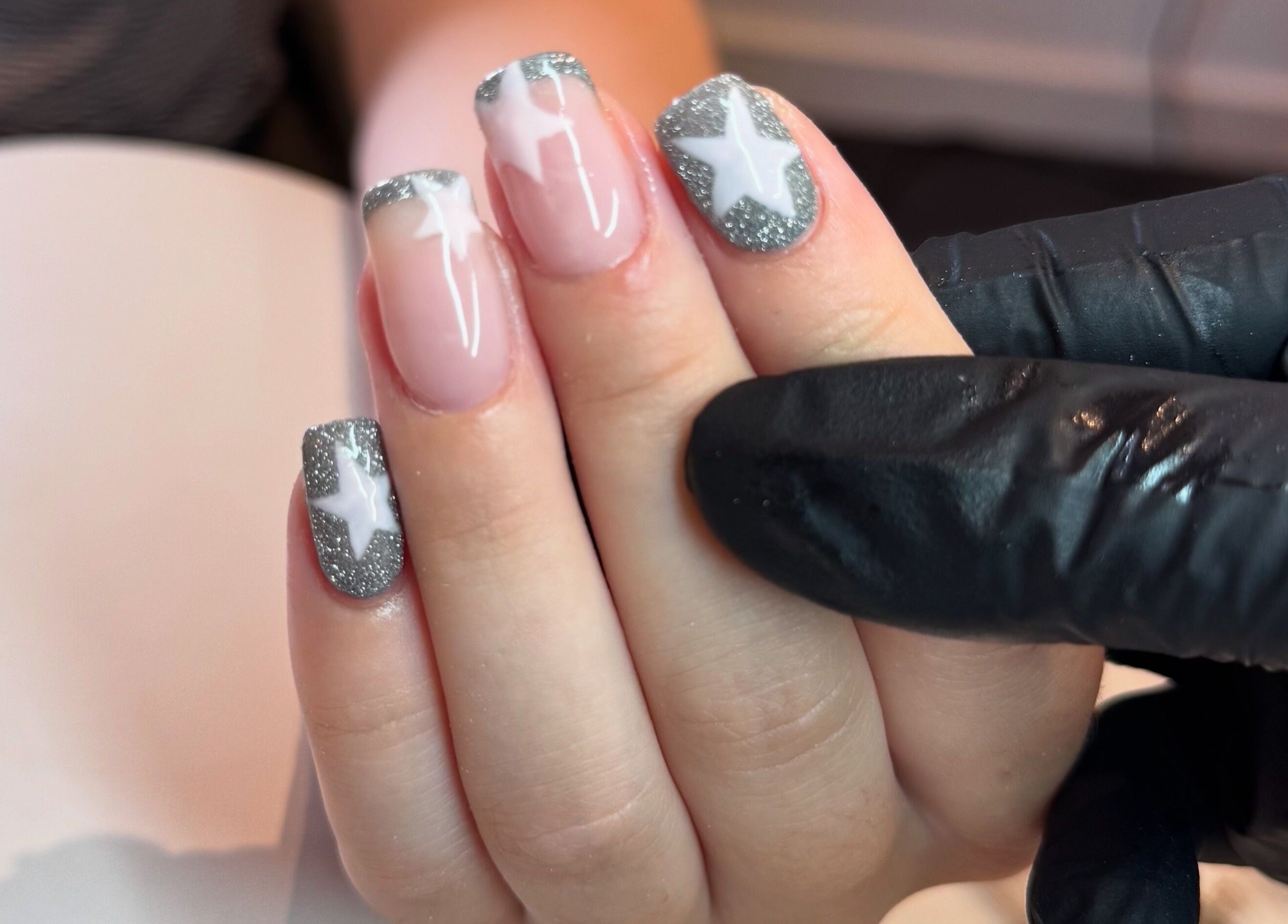 Close-up of star-themed nail art at Beauty By Mols, Somerton, England, GB, featuring silver and white designs.
