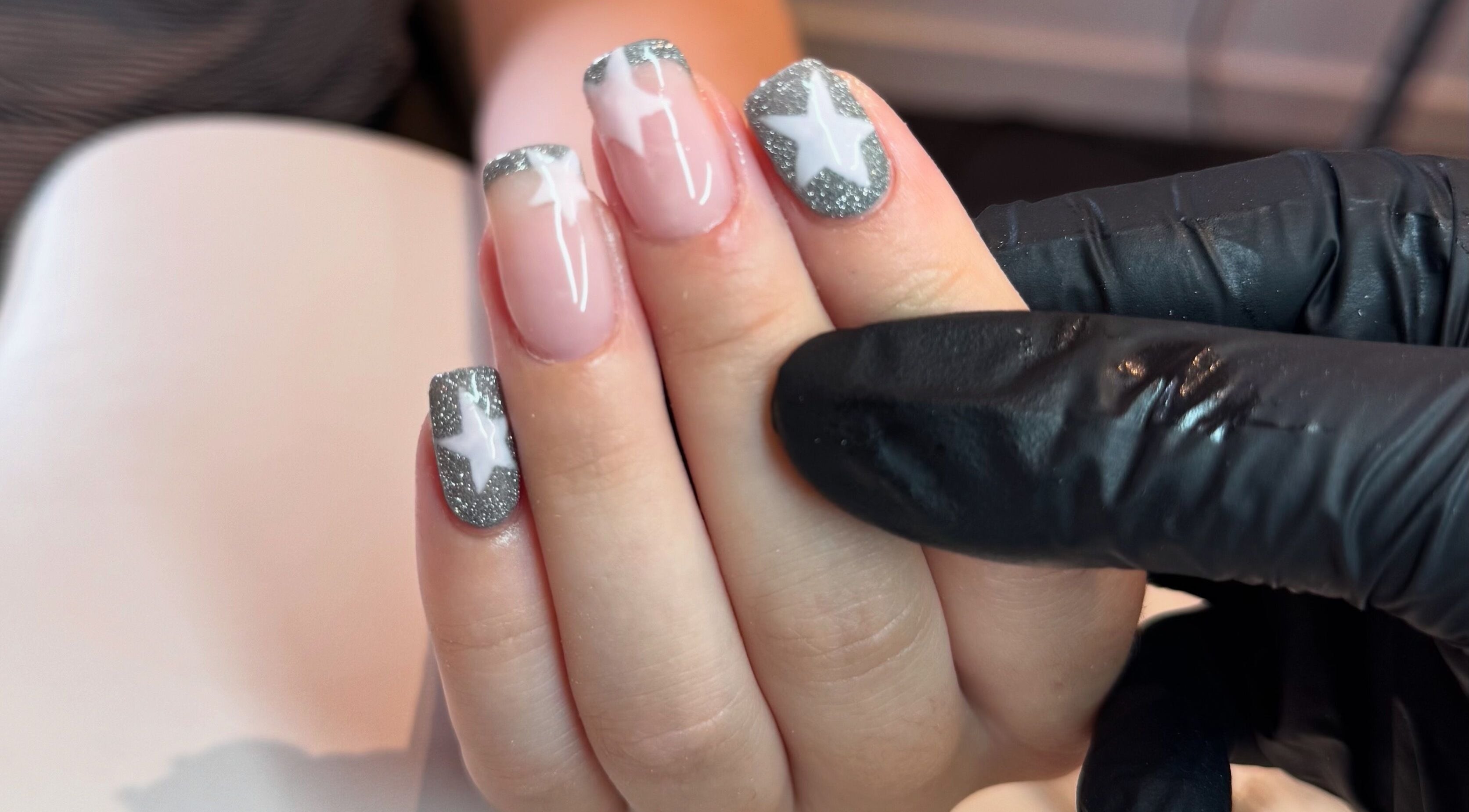 Close-up of star-themed nail art at Beauty By Mols, Somerton, England, GB, featuring silver and white designs.