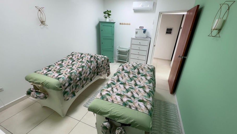 Peaceful massage room at Glorious Touch Day Spa, Oranjestad, AW with elegant decor and floral prints.