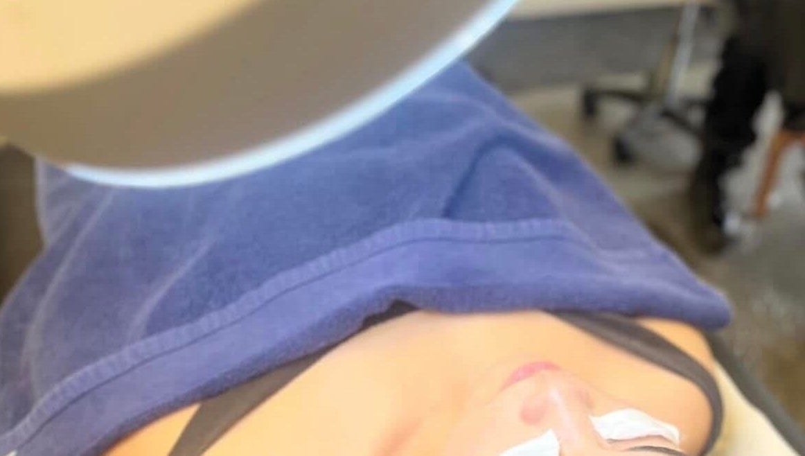 Client enjoying a relaxing facial treatment at RESPIRA SPA in Bermuda, BM, under a soft blue towel.