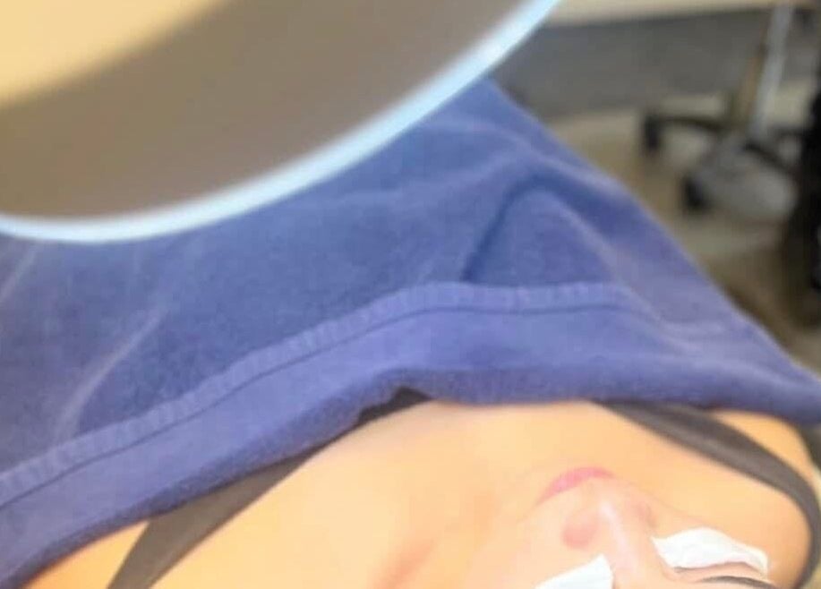 Client enjoying a relaxing facial treatment at RESPIRA SPA in Bermuda, BM, under a soft blue towel.