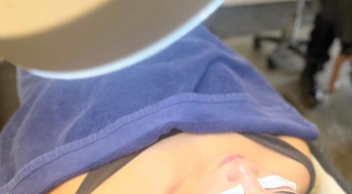 Client enjoying a relaxing facial treatment at RESPIRA SPA in Bermuda, BM, under a soft blue towel.