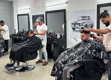 Interior de Barbería Mónaco en Tegucigalpa, Departamento De Francisco Morazán, HN, mostrando barberos trabajando.